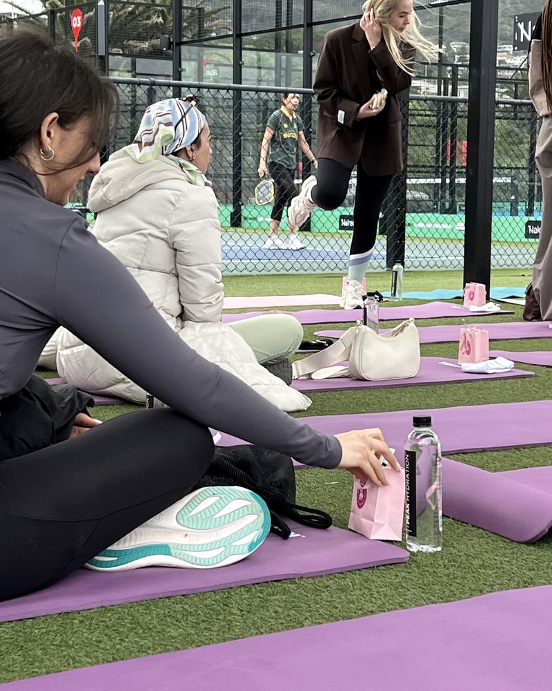 A pilates session on the lawn with Peak Hydration on the mats